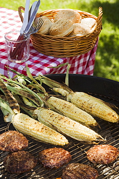 Corn and hamburgers cooking on grill