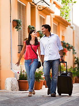 France, Cassis, Couple of tourist walking street with suitcase, France, Cassis