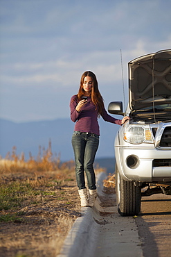 Woman calling for assistance after vehicle breakdown, Whitefish, Montana, USA