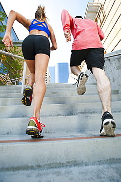 USA, California, Los Angeles, Young man and young woman running on city street, USA, California, Los Angeles