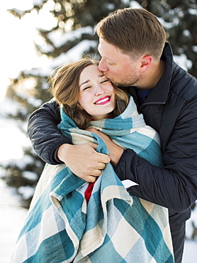 Man kissing woman wrapped in blanket outdoors, Salt Lake City, Utah