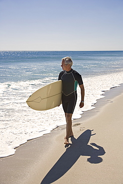 Man carrying surfboard at beach