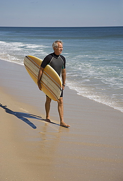 Man carrying surfboard at beach