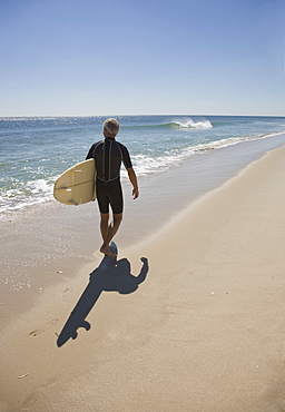 Man carrying surfboard at beach