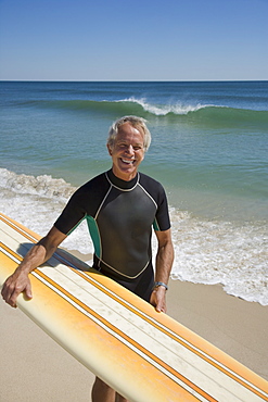 Man holding surfboard at beach