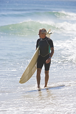 Man carrying surfboard at beach