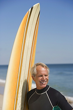 Man next to surfboard at beach