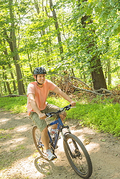Man cycling in forest, USA, New Jersey, Mendham