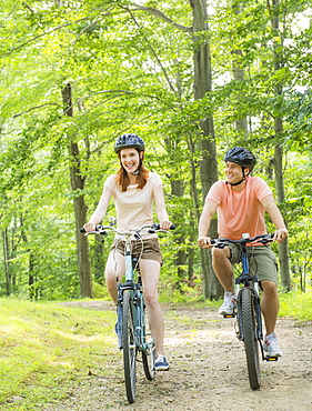 Couple cycling in forest, USA, New Jersey, Mendham
