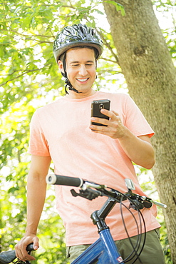 Man texting on mobile during bicycle trip, USA, New Jersey, Mendham