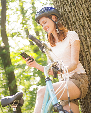 Woman texting on mobile during bicycle trip, USA, New Jersey, Mendham