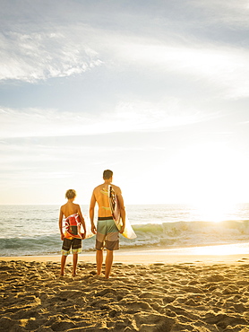 Father and son (14-15) looking at sea, Laguna Beach, California