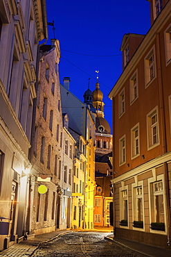 View of illuminated street in old town and Riga Cathedral at dusk, Latvia