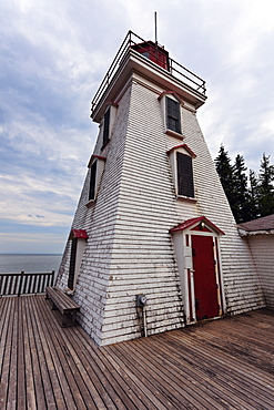 Low angle view of lighthouse and wooden pier, Prince Edward Island, New Brunswick, Canada