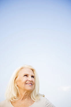 Portrait of senior woman against blue sky