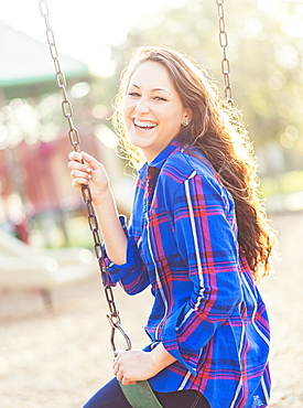 Woman swinging in playground, Jupiter, Florida