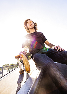 Skateboarder resting in skatepark, West Palm Beach, Florida