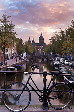 Basilica of st nicholas and bicycle by canal in city, Amsterdam, North Holland, Netherlands