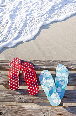 Flip flops on pier by sea