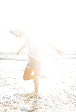 Woman standing on one leg in sea, Jupiter, Florida,USA