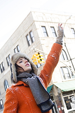 Woman calling taxi in winter, Brooklyn, New York,USA