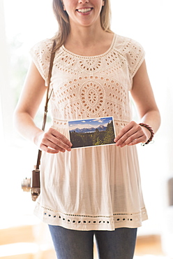 Woman holding antique camera and pictures