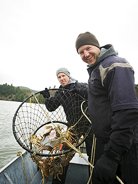 Men showing crabs in net, Rockaway Beach, Oregon