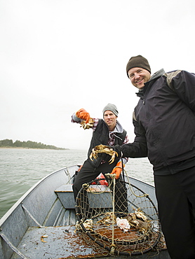 Portrait of men showing crabs, Rockaway Beach, Oregon