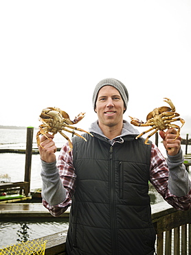 Portrait of man showing crabs, Rockaway Beach, Oregon