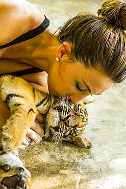 Woman kissing tiger cub