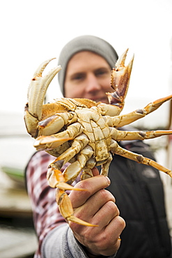 Portrait of man showing crab, Rockaway Beach, Oregon