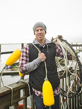 Portrait of man holding fishing equipment, Rockaway Beach, Oregon