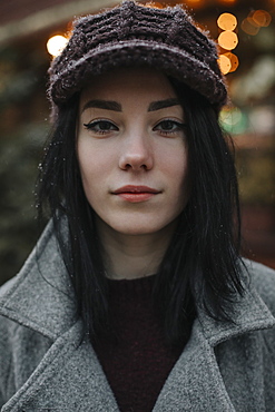 Portrait of young woman wearing woolly hat and eyeliner