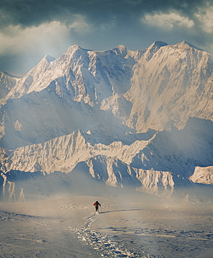 Man hiking through snow by mountain in Alpe Devero, Italy