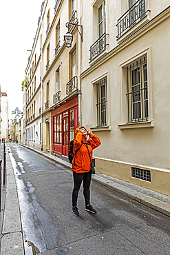 Woman wearing raincoat on street in Paris, France