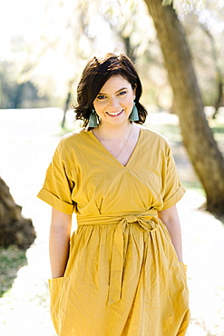 Smiling woman wearing yellow dress in park