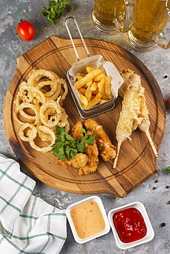 Deep fried snacks on cutting board with sauce