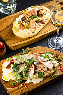 Bread topped with chicken and salmon on cutting boards