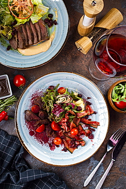 Two beef salads with red wine