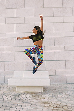 Woman jumping by wall, Lisboa, Lisbon, Portugal