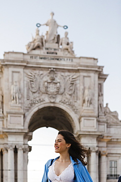 Smiling woman by Rua Augusta Arch in Lisbon, Portugal