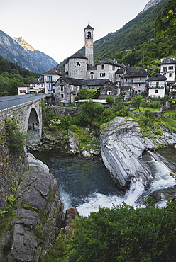 Bell tower by bridge and river in Ticino, Switzerland