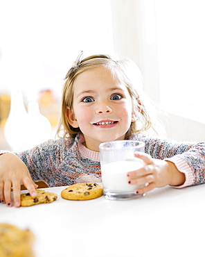 Girl eating milk and cookies