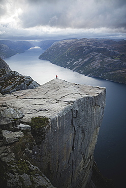 Person standing on Preikestolen cliff in Rogaland, Norway