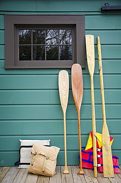 Oars and life jackets by blue wall