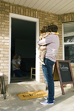 Father with daughter (2-3) visiting friends while keeping distance