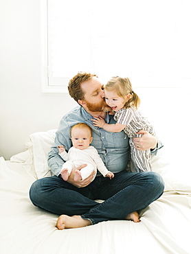 Father sitting on bed with children (2-3 months, 2-3)