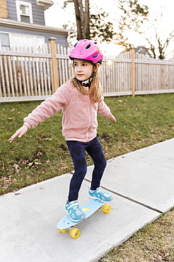 Girl skateboarding down on sidewalk