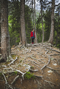 Switzerland, Bravuogn, Palpuognasee, Young woman standing in forest