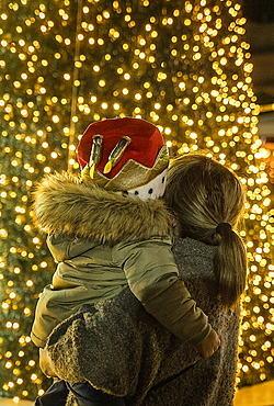 Mother and son watching illuminated Christmas tree